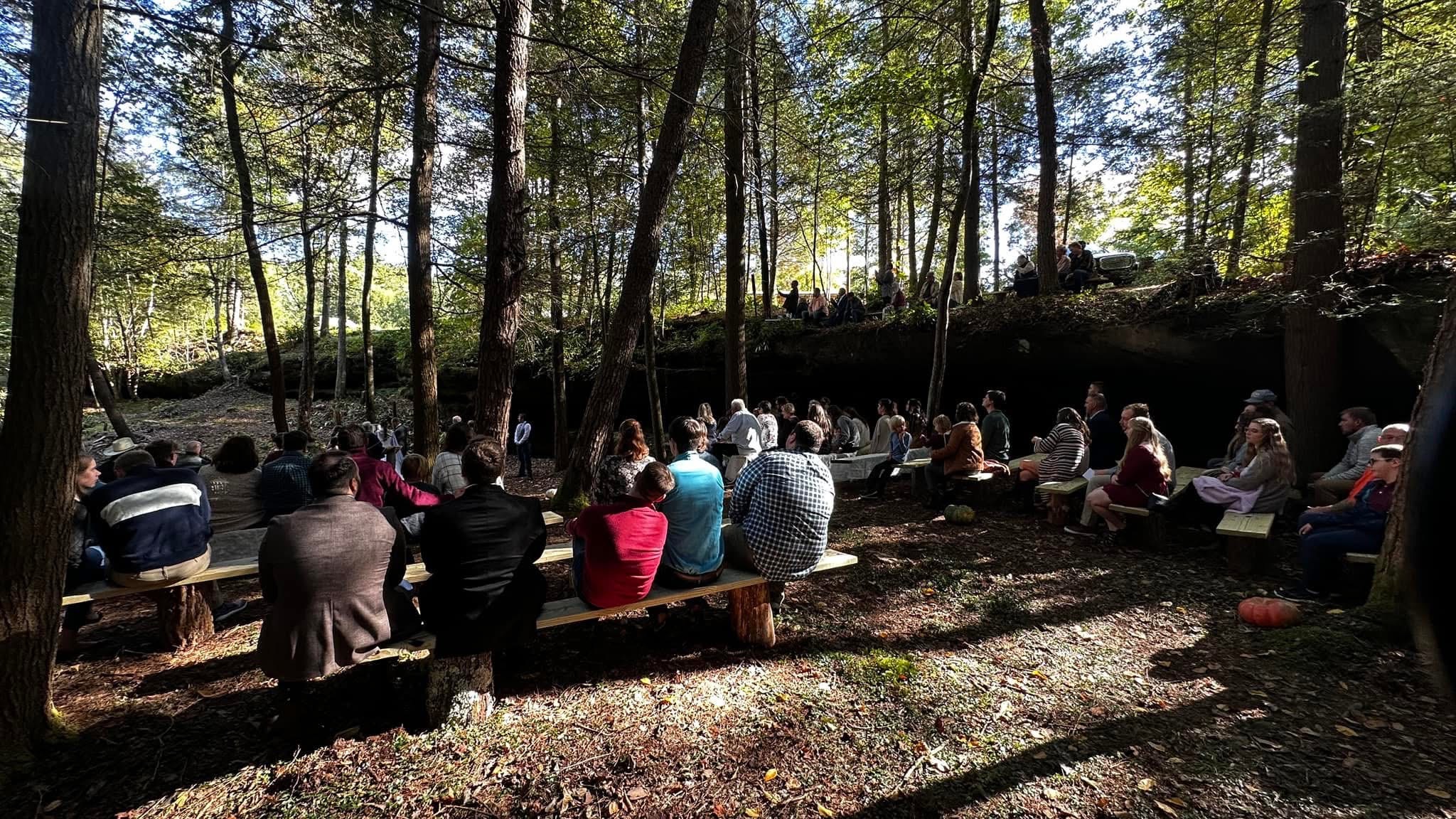 Large outdoor group gathering in the woods at Laurel Creek Campground